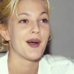 Drew Barrymore con unas cejas finas y el cabello peinado con gel