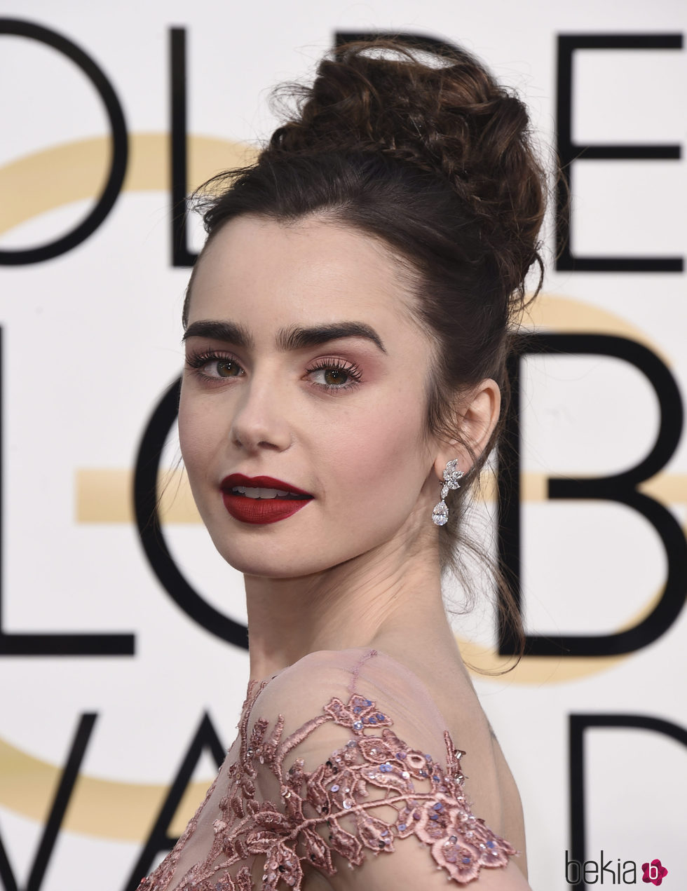 Lily Collins luce un moño alto creado con trenzas