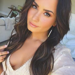 Demi Lovato con extensiones y maquillaje en tonos melocotón