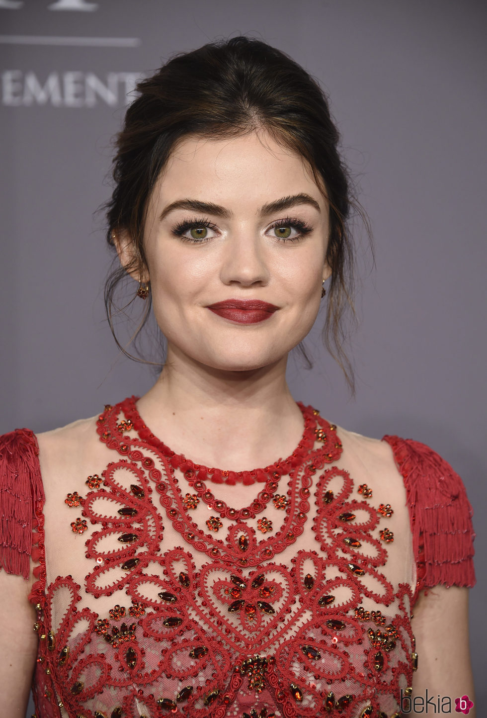 Lucy Hale con un recogido alto y un labial rojo en la gala amfAr