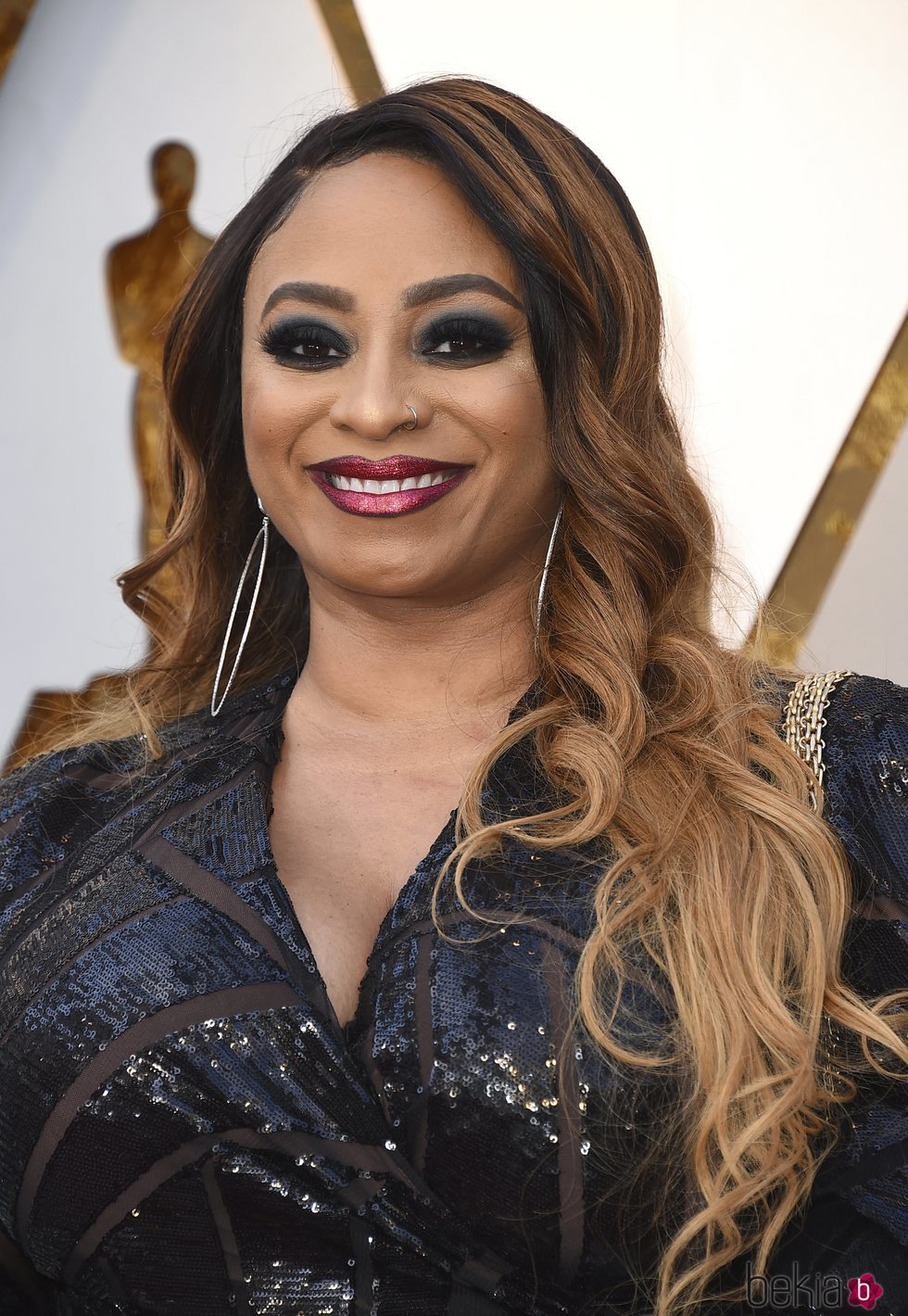 Taura Stinson con el pelo ondulado y sombras negras en los Oscar 2018