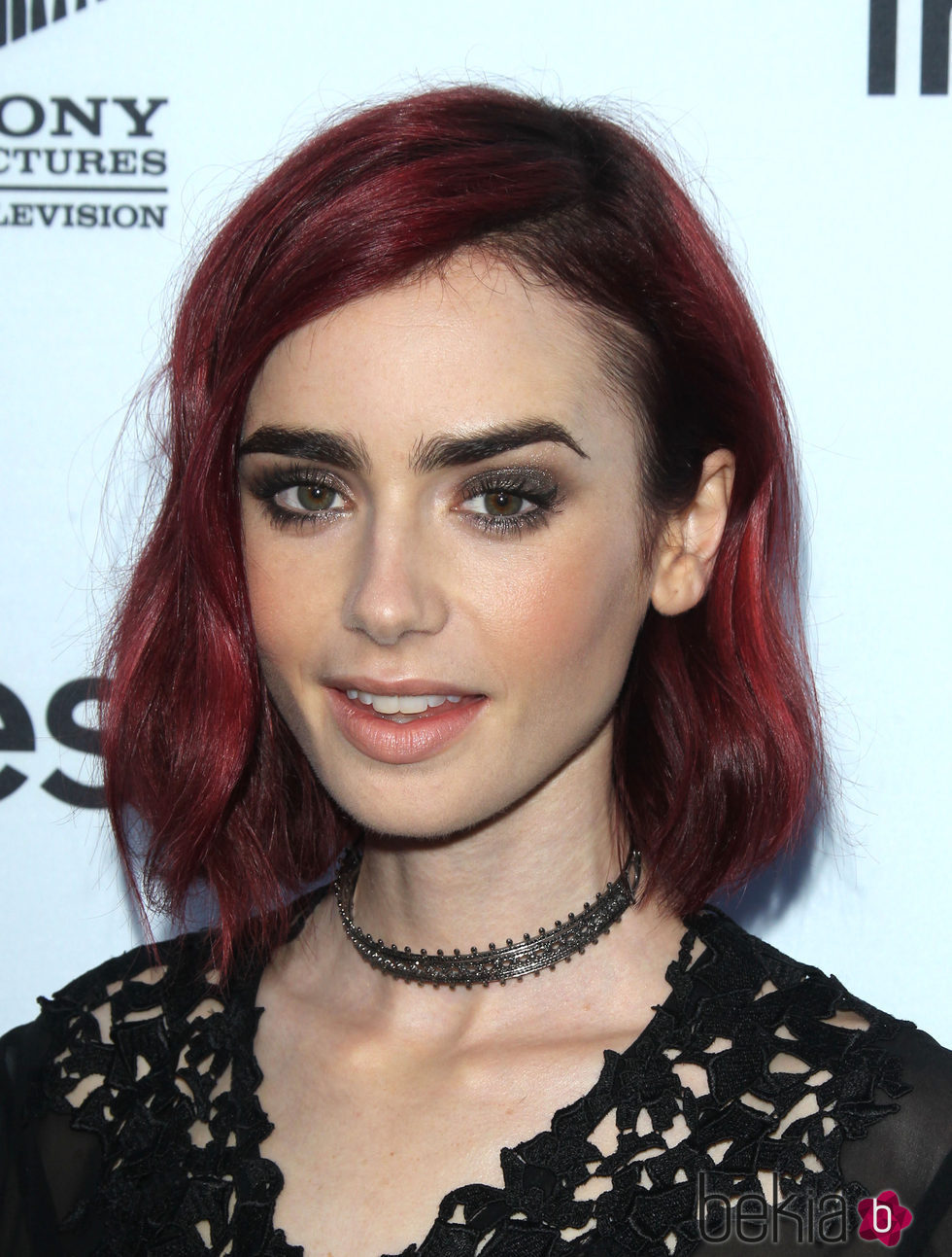 Lily Collins con un peinado midi y un color en granate